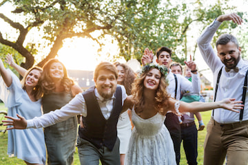 a bride and groom pose with their wedding guests outside